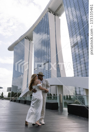 An international wedding. A handsome dark-skinned groom in a white suit 135335461