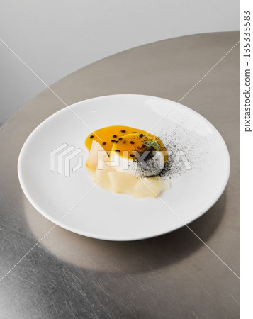 Artistic dish featuring poached scallops and fruit sauce Artistic dish featuring poached scallops and fruit sauce 135335583