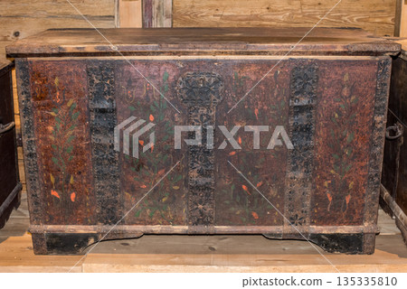 Old wooden chest against wooden wall 135335810