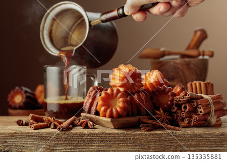 Cinnamon cakes and black coffee on an old wooden table. Cinnamon cakes and black coffee on an old wooden table. 135335881
