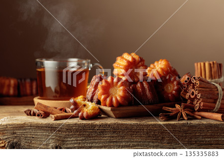 Cinnamon cakes and tea on an old wooden table. 135335883