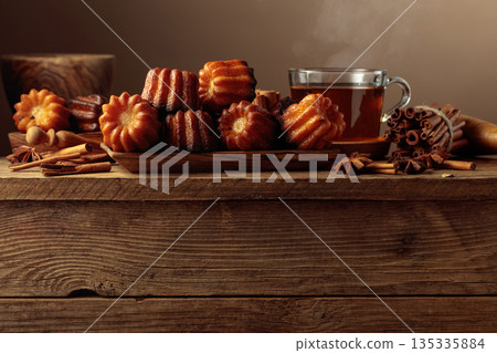 Cinnamon cakes and tea on an old wooden table. 135335884