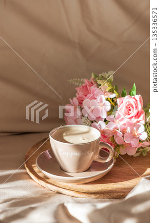 Cappuccino Cup and Flowers on Tray with Satin Bedding in Sunlight. Valentine's or Mother's Day Celebration 135336571