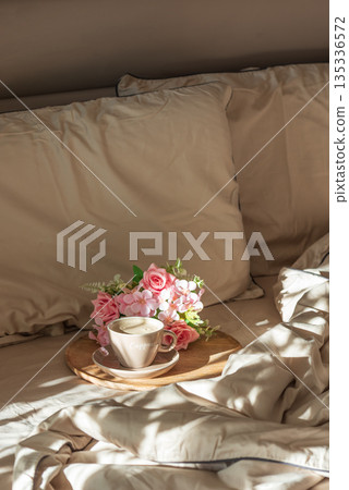 Cappuccino Cup and Flowers on Tray with Satin Bedding in Sunlight. Valentine's or Mother's Day Celebration Cappuccino Cup and Flowers on Tray with Satin Bedding in Sunlight. Valentine's or Mother's Day Celebration 135336572