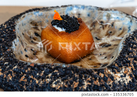 Gourmet dish with caviar and edible flower served in a unique ceramic bowl Gourmet dish with caviar and edible flower served in a unique ceramic bowl 135336705
