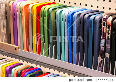 Colorful smartphone cases arranged on retail shelf in electronics store display Colorful smartphone cases arranged on retail shelf in electronics store display 135336943