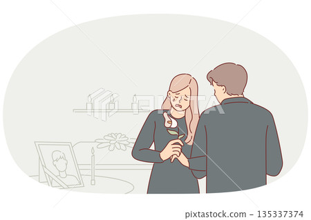 Widow woman cries at funeral standing near table with portrait of deceased husband at mourning event Widow woman cries at funeral standing near table with portrait of deceased husband at mourning event 135337374