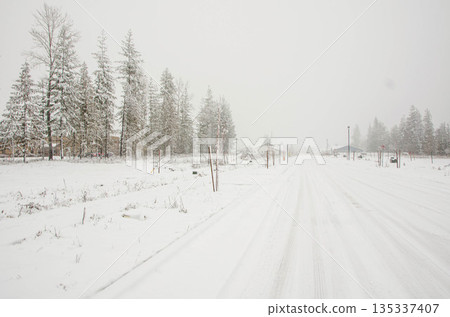 Snow Covered Rural Road During Winter Snowfall in Idaho 135337407