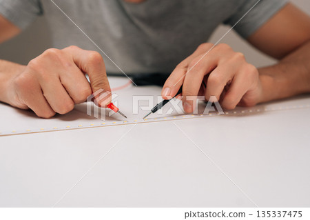 Person testing led strip light circuit with multimeter probes, hands holding the measurement tools while checking electrical properties and repairing electronics with expertise. 135337475