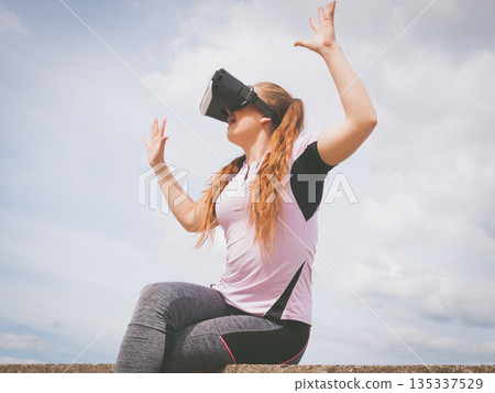 Woman wearing VR outside Woman wearing VR outside 135337529