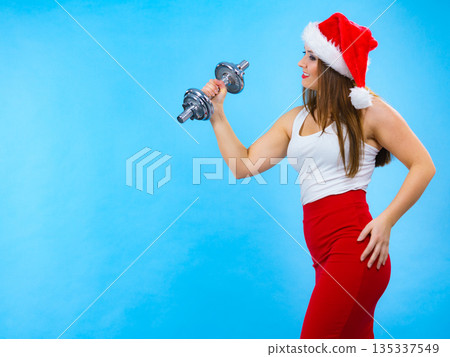 Santa claus woman lifting dumbbells Santa claus woman lifting dumbbells 135337549
