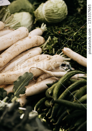 Fresh Root Vegetables At Market Stall: White Radishes, Green Beans, And Cabbage Displayed In Natural Seasonal Food Market Arrangement 135337665