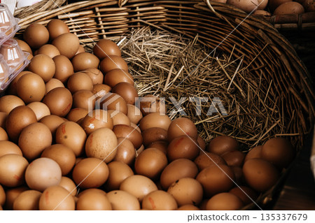 Fresh Brown Eggs In Wicker Basket: Natural Farm Eggs Arranged On Straw In Traditional Food Market Setting 135337679