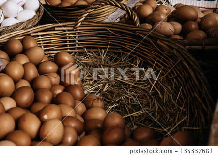 Fresh Brown Eggs In Wicker Basket: Natural Farm Eggs Arranged On Straw In Traditional Food Market Setting 135337681