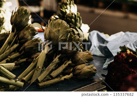 Fresh Green Artichokes At Market Stall: Raw Seasonal Vegetables With Leaves And Stems Displayed In Natural Organic Arrangement 135337682