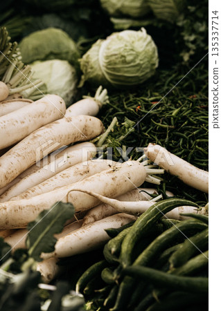 Fresh Root Vegetables At Market Stall: White Radishes, Green Beans, And Cabbage Displayed In Natural Seasonal Food Market Arrangement 135337714