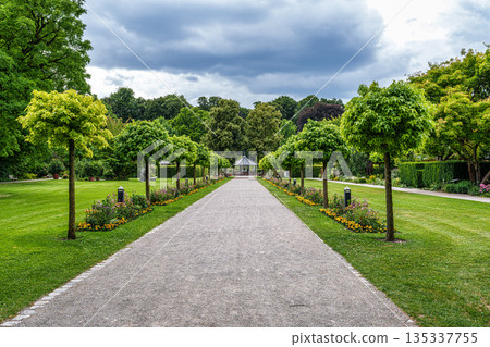 The Botanical Garden of Augsburg in Germany with garden pathes and topiary boxwood bushes on green meadows 135337755