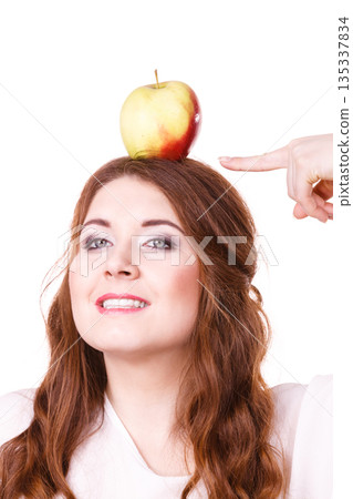 Woman funny girl holds on head apple fruit Woman funny girl holds on head apple fruit 135337834