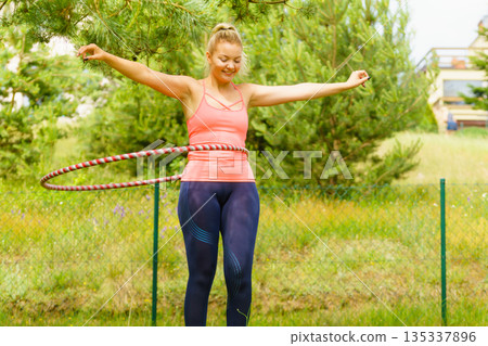 Young woman with hoola hoop outdoors 135337896