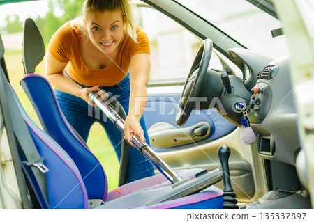 Cleaning car interior with vacuum cleaner 135337897