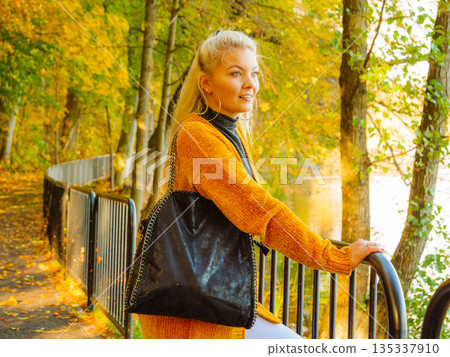 Woman walking in autumn park Woman walking in autumn park 135337910