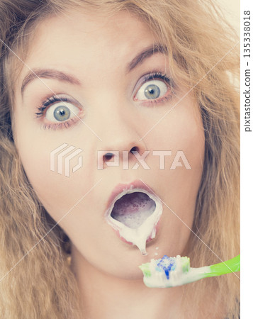 Woman brushing cleaning teeth 135338018