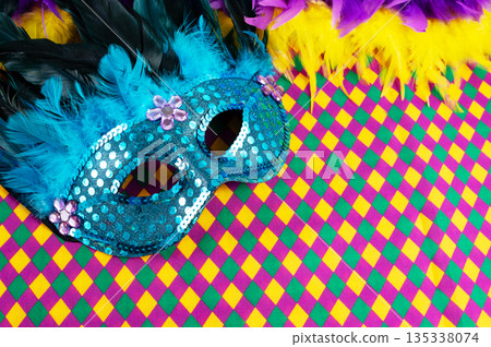 Top view of a beautiful composition of colorful masks, confetti, Mardi Gras decorations. Yellow Mardi Gras banner. 135338074