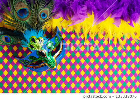 Top view of a beautiful composition of colorful masks, confetti, Mardi Gras decorations. Yellow Mardi Gras banner. Top view of a beautiful composition of colorful masks, confetti, Mardi Gras decorations. Yellow Mardi Gras banner. 135338076