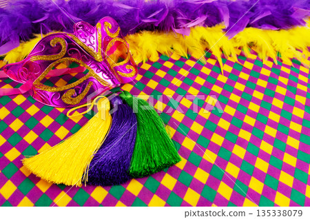 Top view of a beautiful composition of colorful masks, confetti, Mardi Gras decorations. Yellow Mardi Gras banner. 135338079
