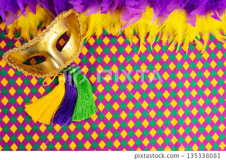 Top view of a beautiful composition of colorful masks, confetti, Mardi Gras decorations. Yellow Mardi Gras banner. Top view of a beautiful composition of colorful masks, confetti, Mardi Gras decorations. Yellow Mardi Gras banner. 135338081