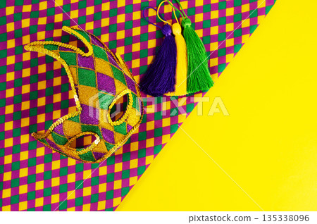 Top view of a beautiful composition of colorful masks, confetti, Mardi Gras decorations. Yellow Mardi Gras banner. Top view of a beautiful composition of colorful masks, confetti, Mardi Gras decorations. Yellow Mardi Gras banner. 135338096