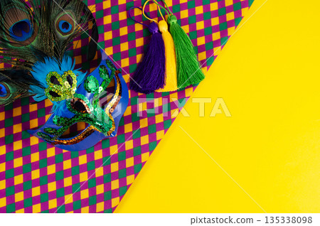 Top view of a beautiful composition of colorful masks, confetti, Mardi Gras decorations. Yellow Mardi Gras banner. 135338098