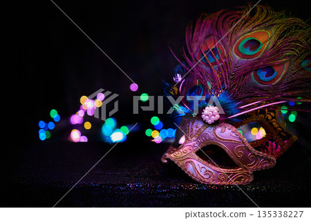 Venetian carnival mask with peacock feathers and bokeh lights Venetian carnival mask with peacock feathers and bokeh lights 135338227