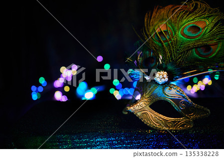 Masquerade mask with peacock feathers bringing mystery and celebration bokeh lights Masquerade mask with peacock feathers bringing mystery and celebration bokeh lights 135338228