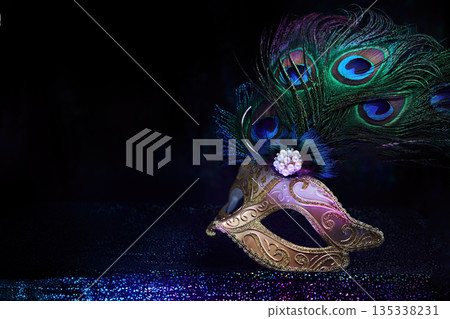 Masquerade mask with peacock feathers representing carnival mystery 135338231