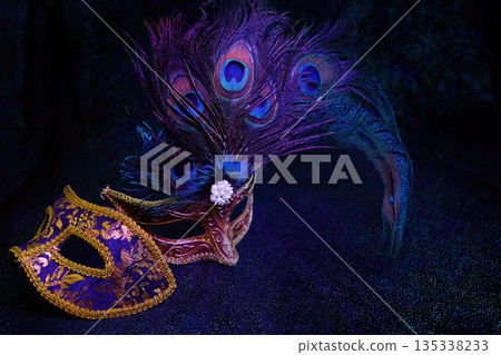 Venetian carnival masks with peacock feathers on dark background 135338233