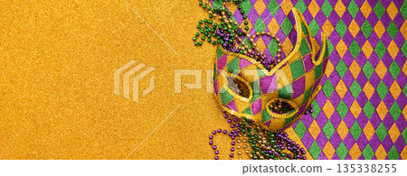 Mardi gras mask and beads on golden glitter background Mardi gras mask and beads on golden glitter background 135338255