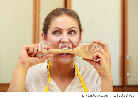 Housewife with ladle in kitchen Housewife with ladle in kitchen 135338465