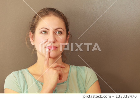 Thoughtful emotional woman in studio Thoughtful emotional woman in studio 135338476