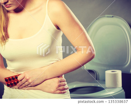 Woman suffer from belly pain holds pills in toilet Woman suffer from belly pain holds pills in toilet 135338637