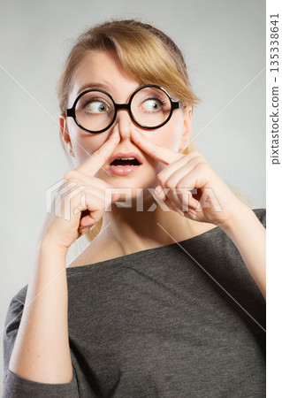 Girl pinches her nose because of stench stink. Girl pinches her nose because of stench stink. 135338641