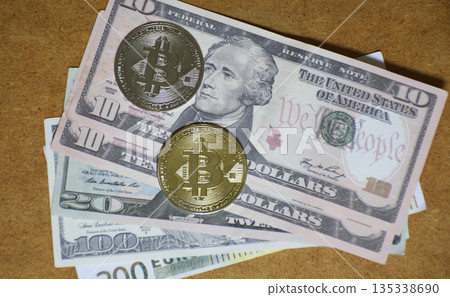 Two Bitcoin coins and dollar bills on a wooden background Two Bitcoin coins and dollar bills on a wooden background 135338690