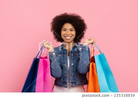 Smiling woman holding colorful shopping bags, consumer lifestyle and retail concept Smiling woman holding colorful shopping bags, consumer lifestyle and retail concept 135338939