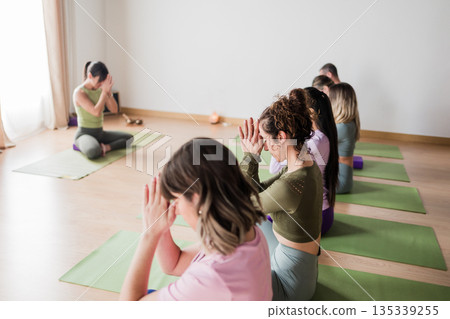 Diverse women practicing yoga meditation in studio Diverse women practicing yoga meditation in studio 135339255