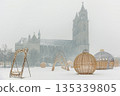 Winter scene Domplatz Magdeburg Dom cathedral silhouette snow fog background festive Lichterwelt light installation. Snow cover square cold weather holiday decoration historic architecture cityscape 135339805