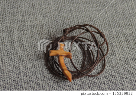 Wooden cross on a dark cord symbolizing resurrection, and the spiritual journey during Lent and Easter 135339932