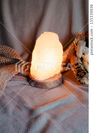 Glowing salt lamp creating a serene atmosphere, emanating warm light for meditation Glowing salt lamp creating a serene atmosphere, emanating warm light for meditation 135339936