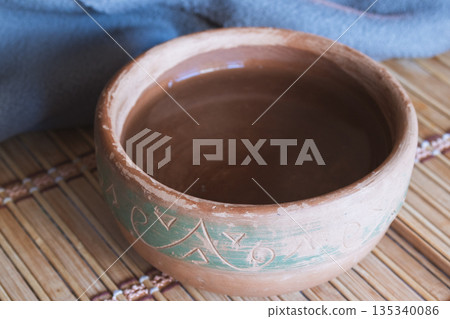 An ancient bowl with water on a bamboo mat, symbolizing spirituality, faith, and meditation An ancient bowl with water on a bamboo mat, symbolizing spirituality, faith, and meditation 135340086