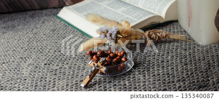 Open Bible, wooden rosary with crucifix on a knitted blanket, arranged for quiet prayer reflection Open Bible, wooden rosary with crucifix on a knitted blanket, arranged for quiet prayer reflection 135340087