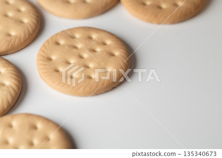 Close-up of round biscuits lined up on a white background Close-up of round biscuits lined up on a white background 135340673
